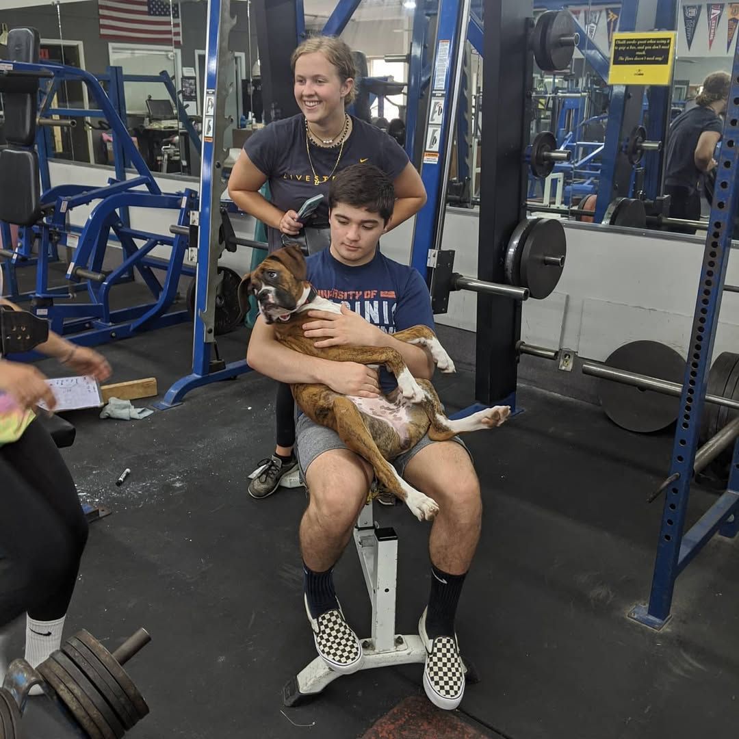 A group of young men are posing for a picture in a boxing gym.