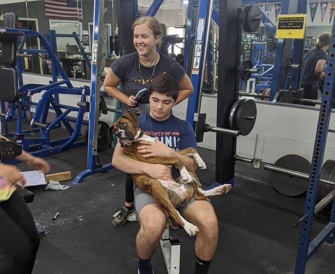 A group of young men are posing for a picture in a boxing gym.