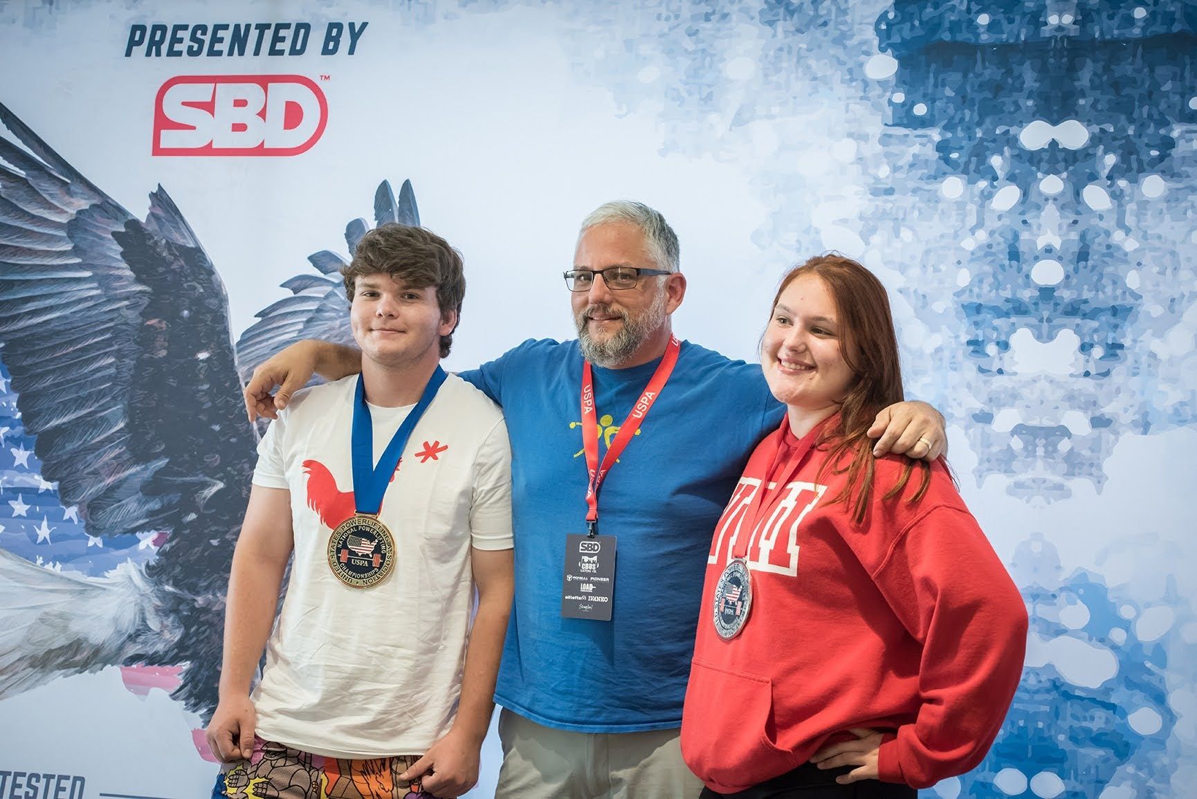 A man , a boy , and a woman are posing for a picture.