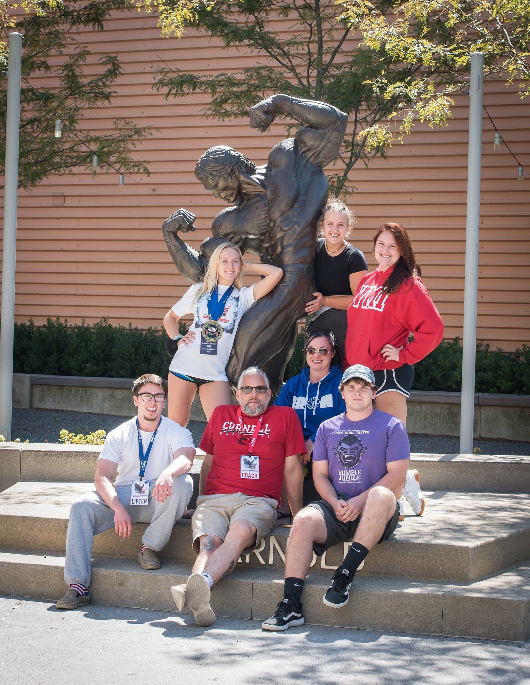 A group of people posing for a picture in front of a statue