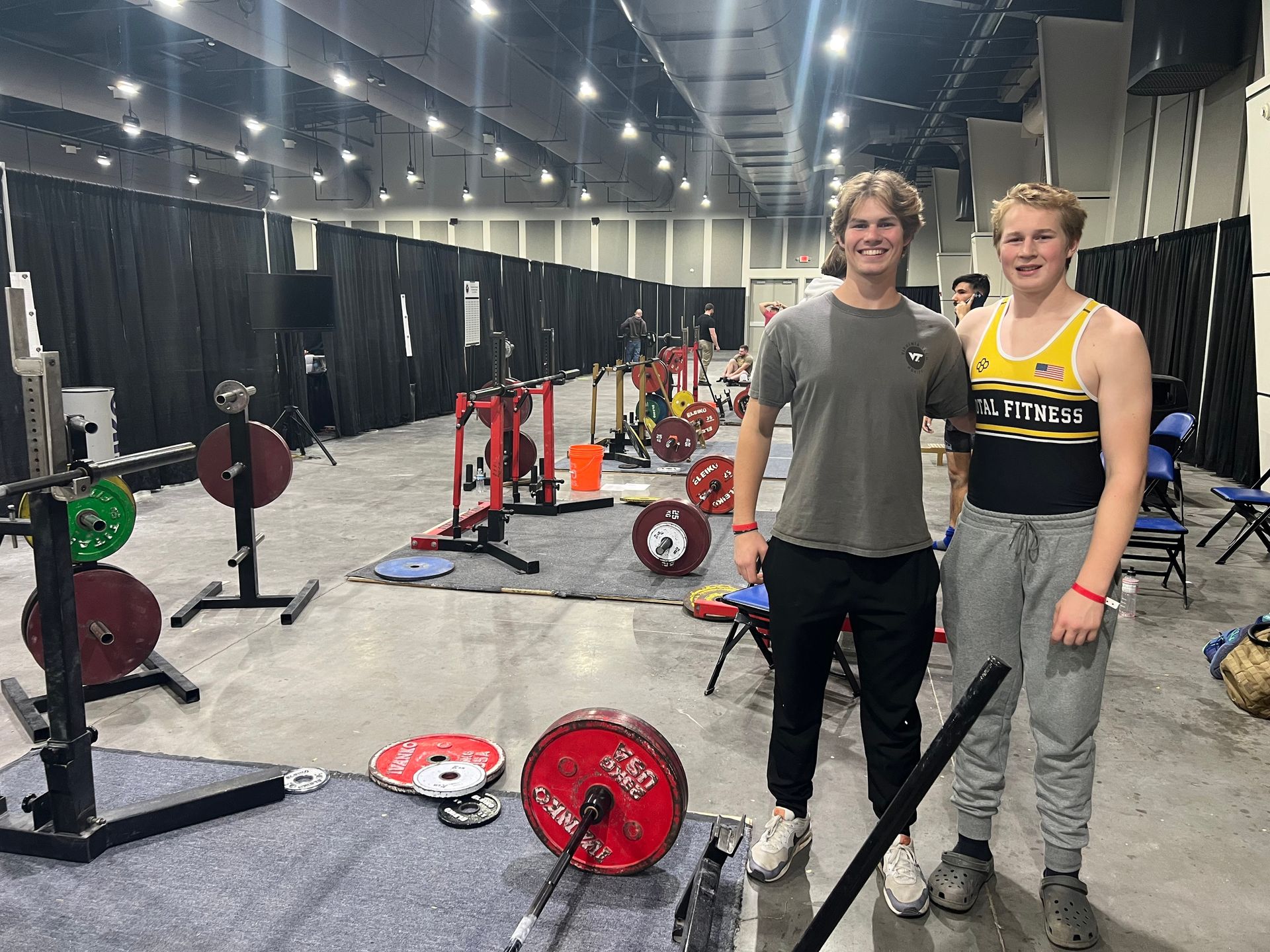 Two young men are standing next to each other in a gym.