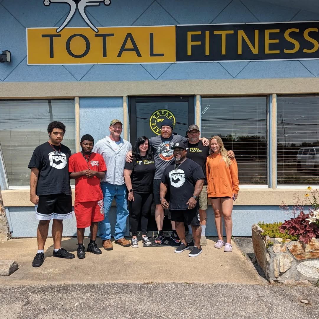 A group of people standing in front of a total fitness building