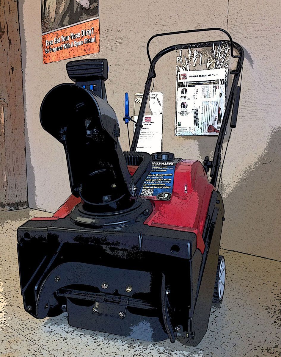 Red and black snowblower with large chute, displayed indoors with product tags.