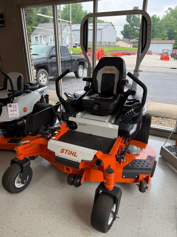 Orange and white STIHL zero-turn lawn mower on display in a showroom.