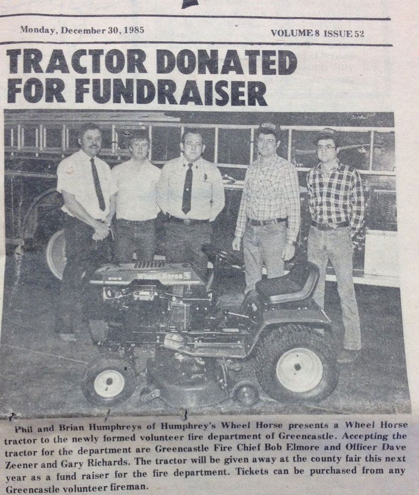 Men stand near a donated tractor, a fundraiser for the volunteer fire department in Greencastle.
