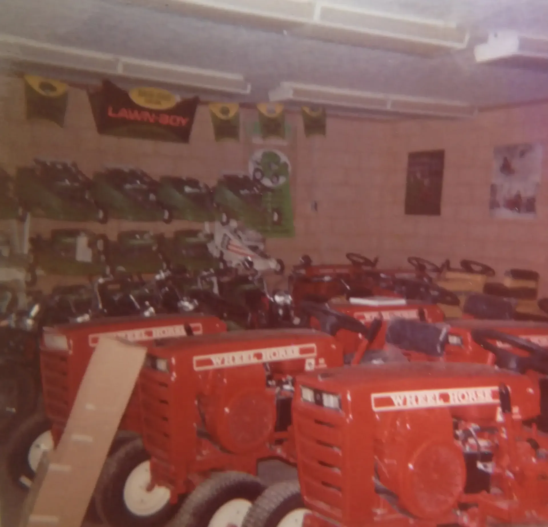 Family of four poses near a tractor. Mother in a suit, father in a jacket, and two children hold hands.