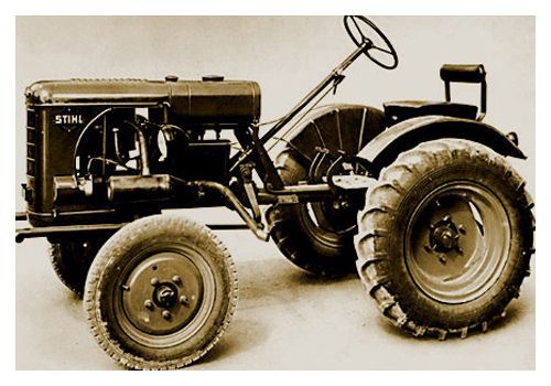 Vintage gray tractor with large rear tires and a steering wheel.