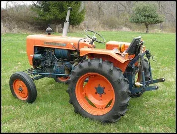 Orange and blue Kubota tractor on a grassy field.
