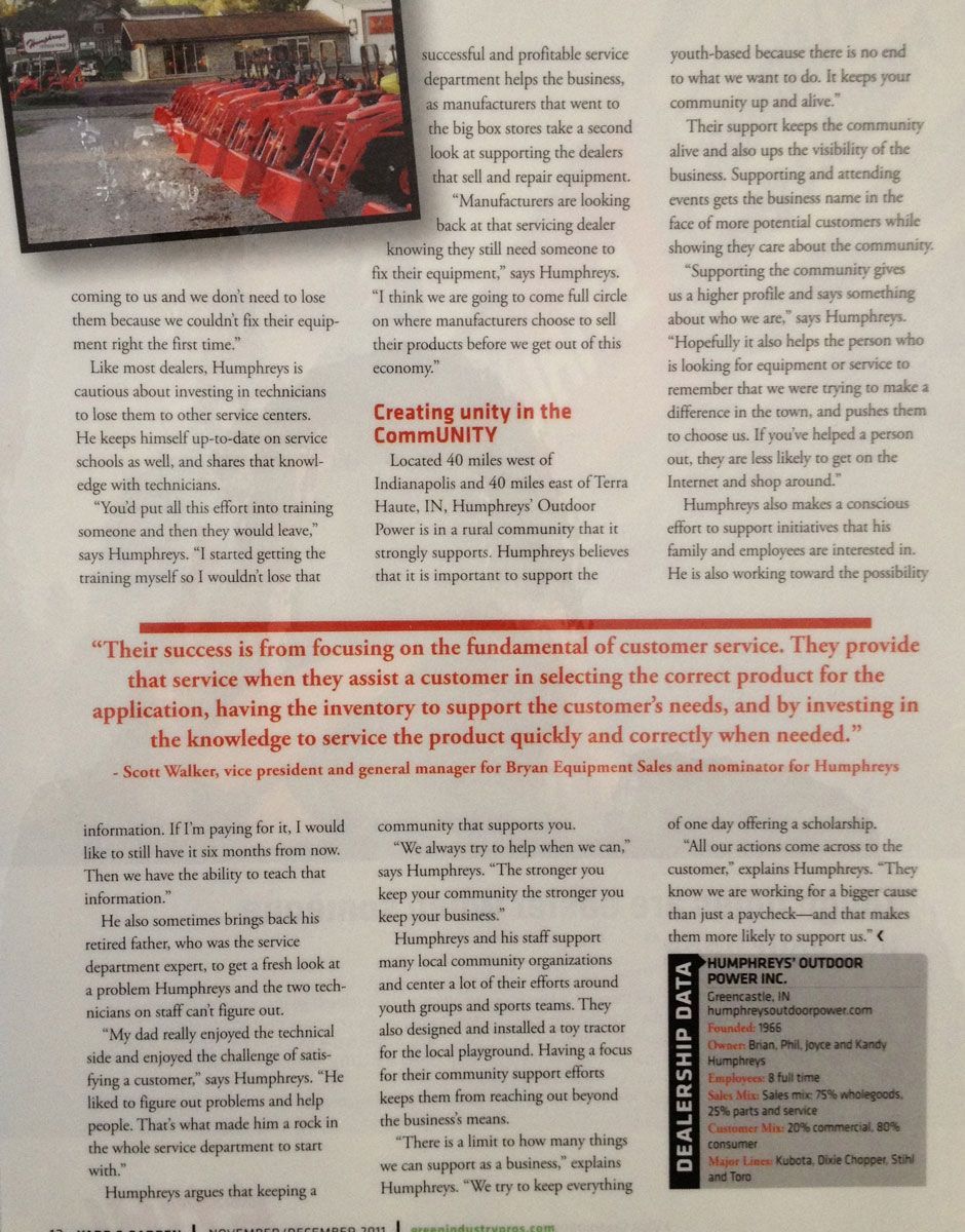 Red plastic chairs stacked outdoors, possibly for sale or an event. Buildings in the background.