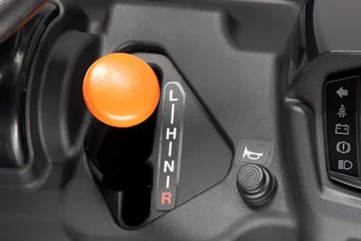 Orange gear shift knob with L, H, N, R indicator, a horn button, and indicator lights on a vehicle dashboard.