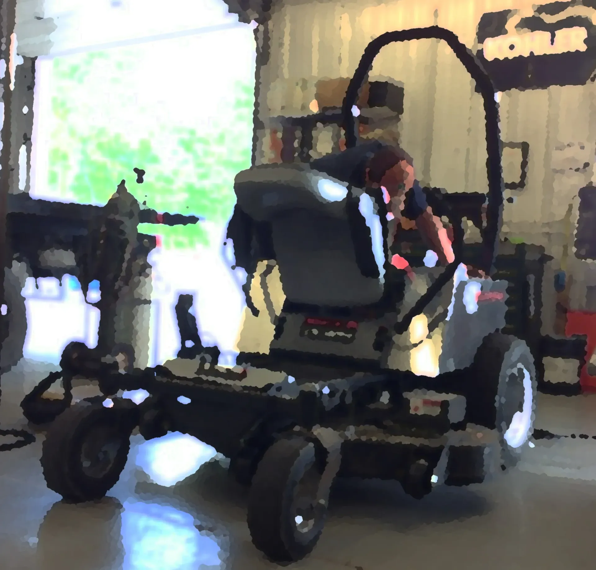 Person working on a black and gray zero-turn lawnmower inside a garage.