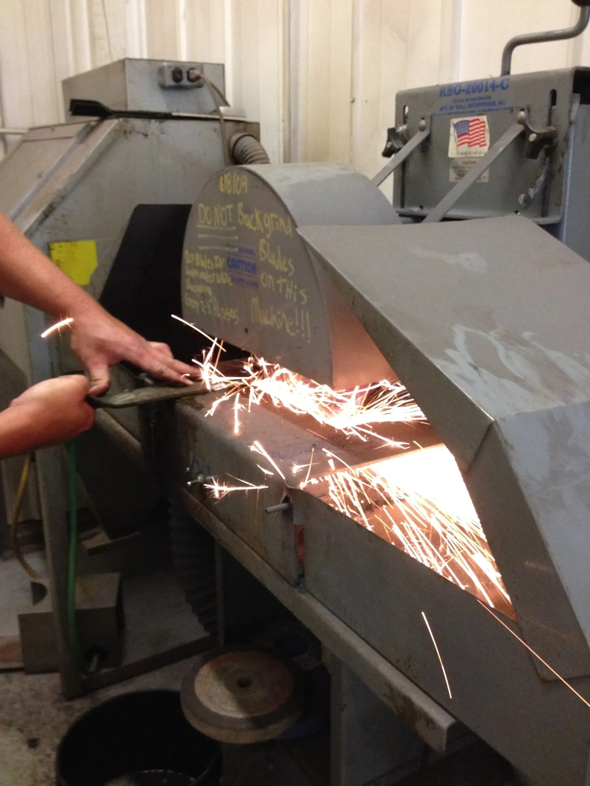 A person using a grinding machine, sparks flying.