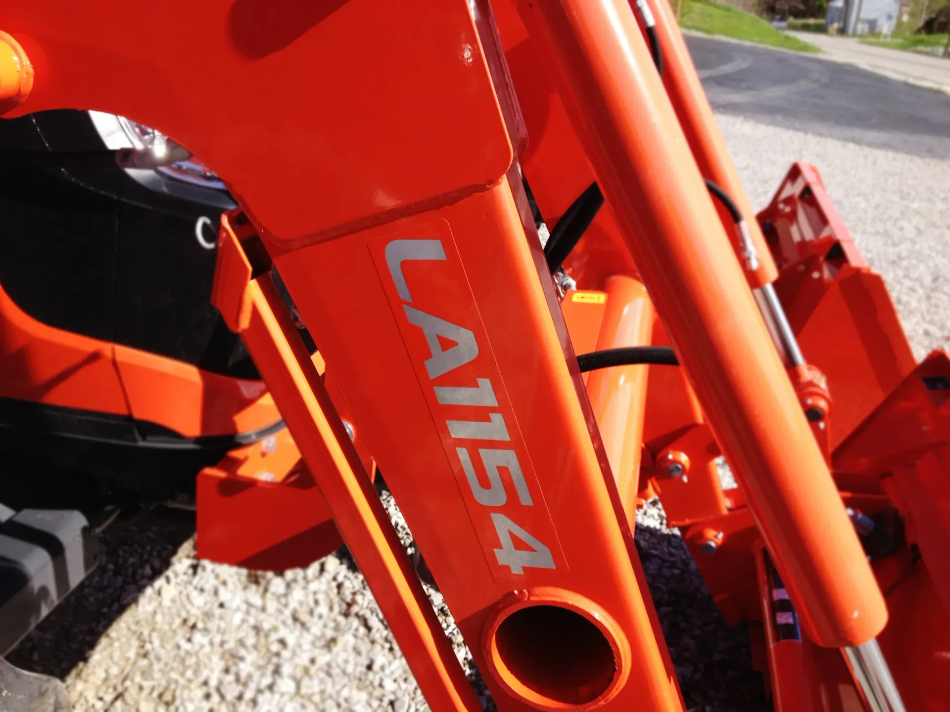 Bright orange Kubota tractor loader arm with 