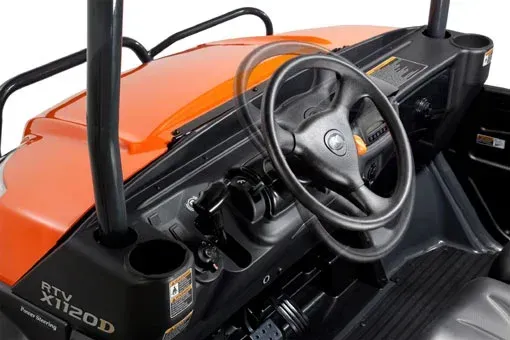 Orange and black Kubota utility vehicle interior with steering wheel and cup holder.