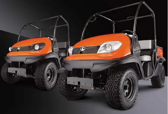 Two orange utility vehicles with black roll bars and tires, set against a dark background.