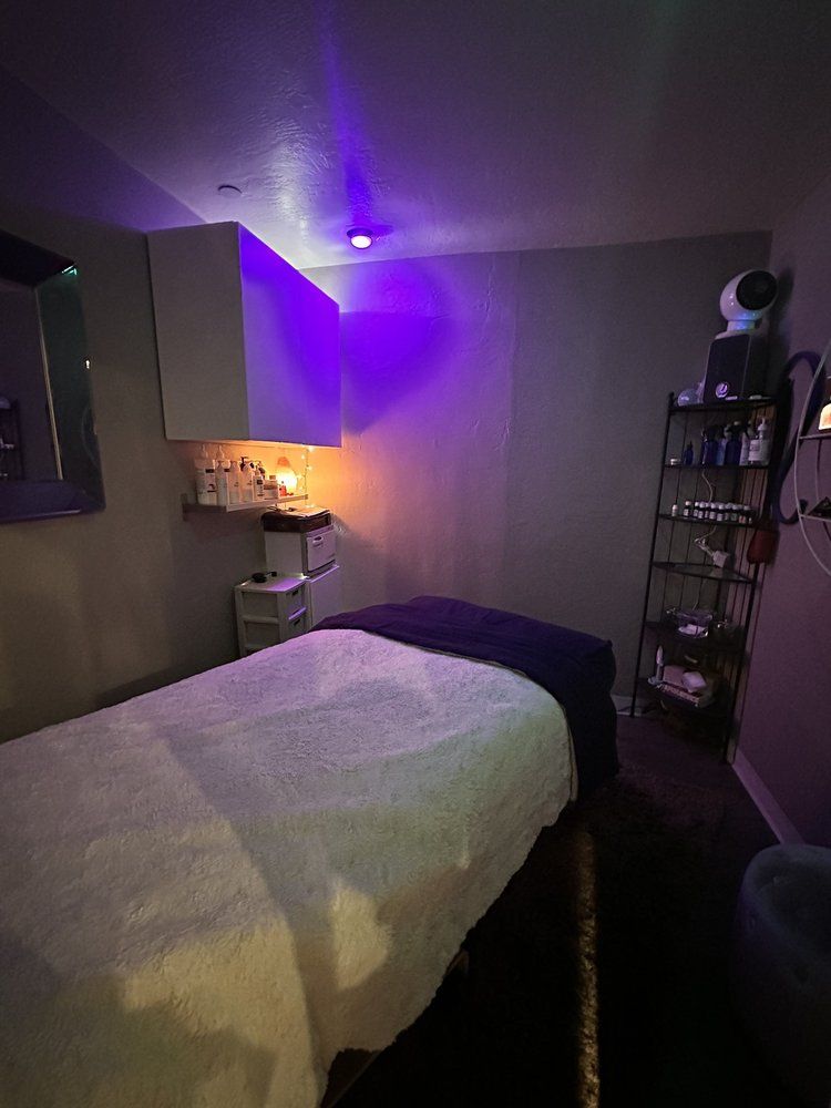 A massage table in a room with purple lights.