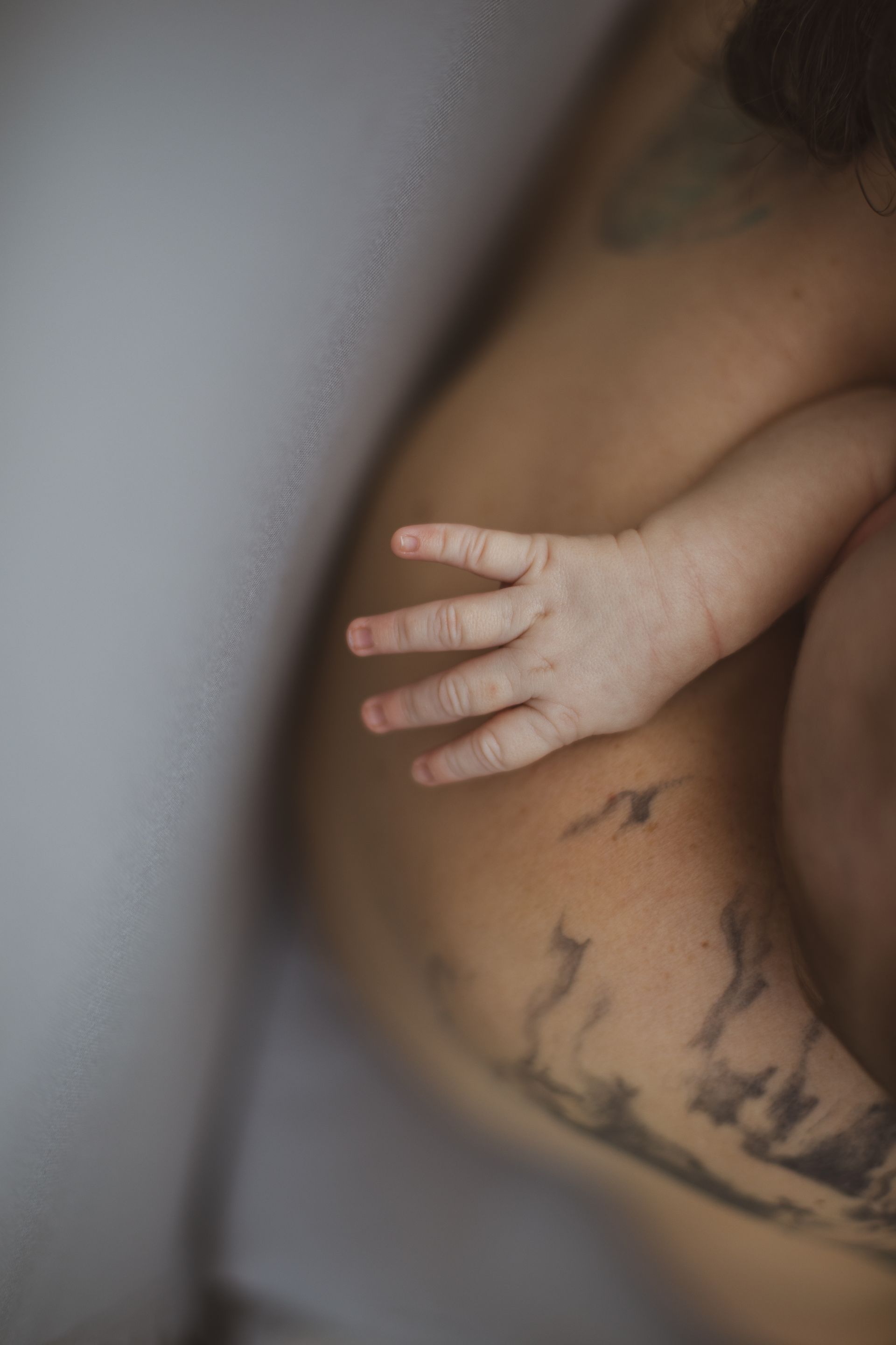 A close up of a baby 's hand on a parent's shoulder.
