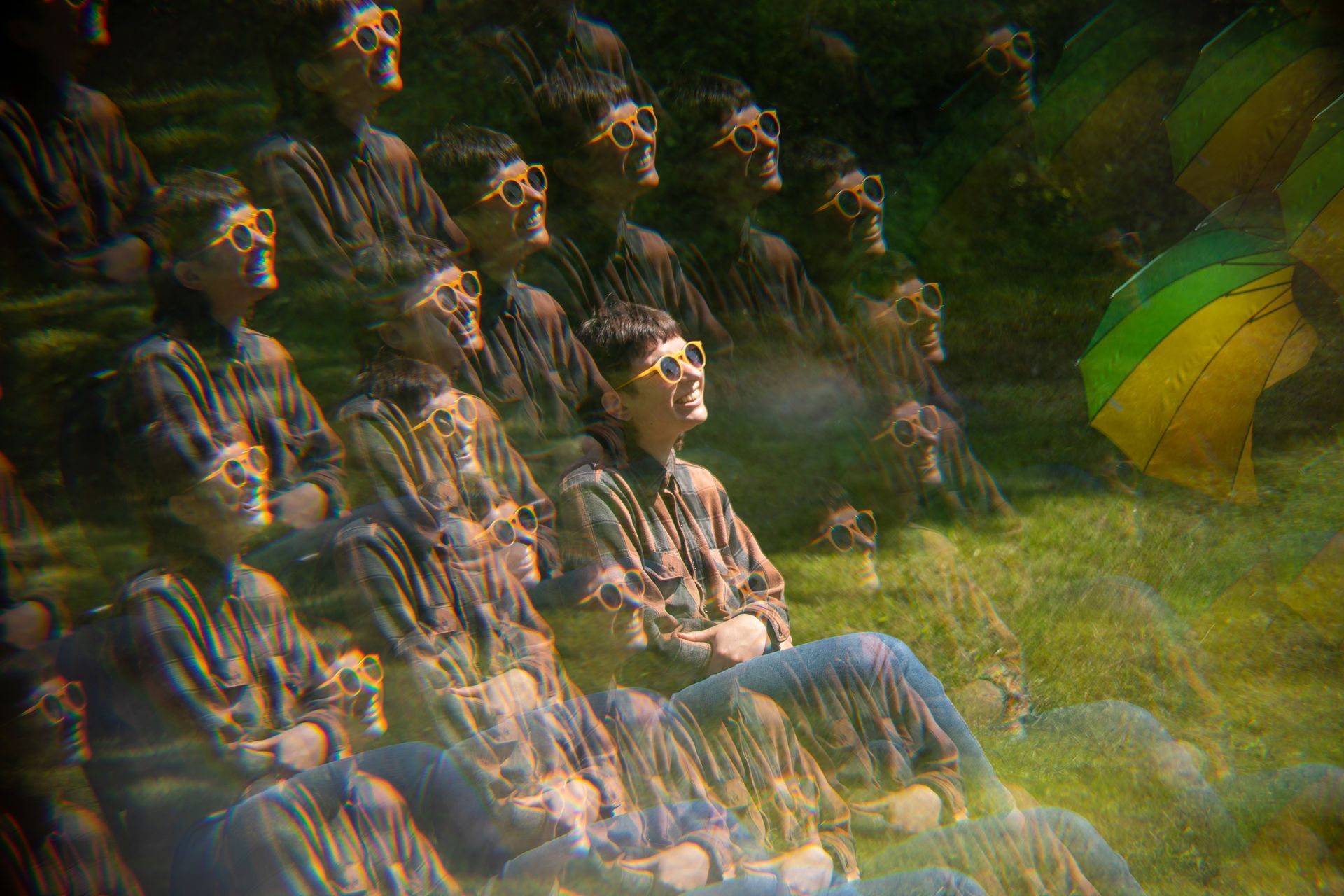 A group of people wearing glasses are sitting in the grass.