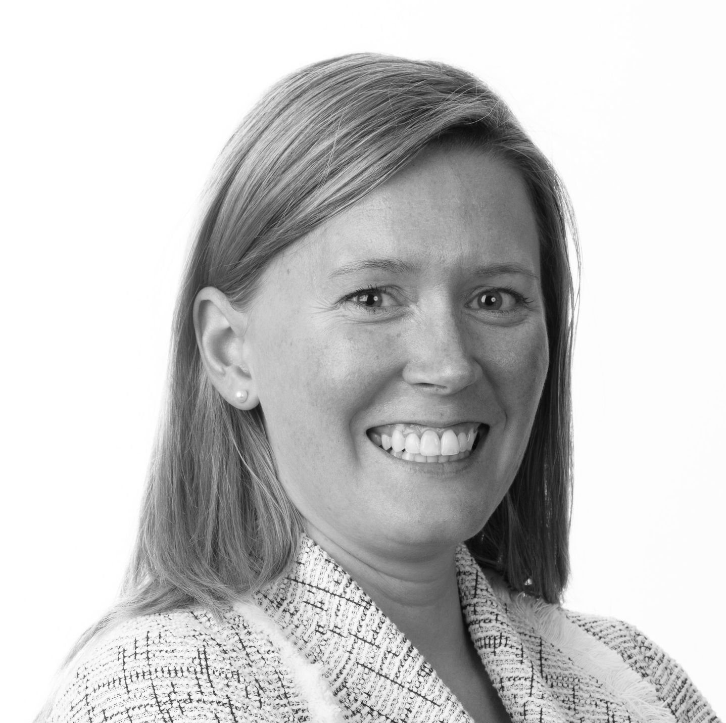 Man in suit and glasses looking to the side with a slight smirk.