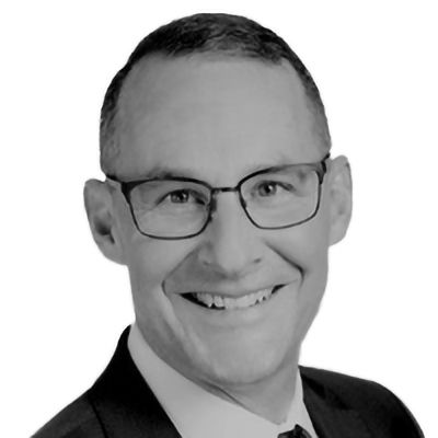 Man wearing glasses smiles, looking forward.