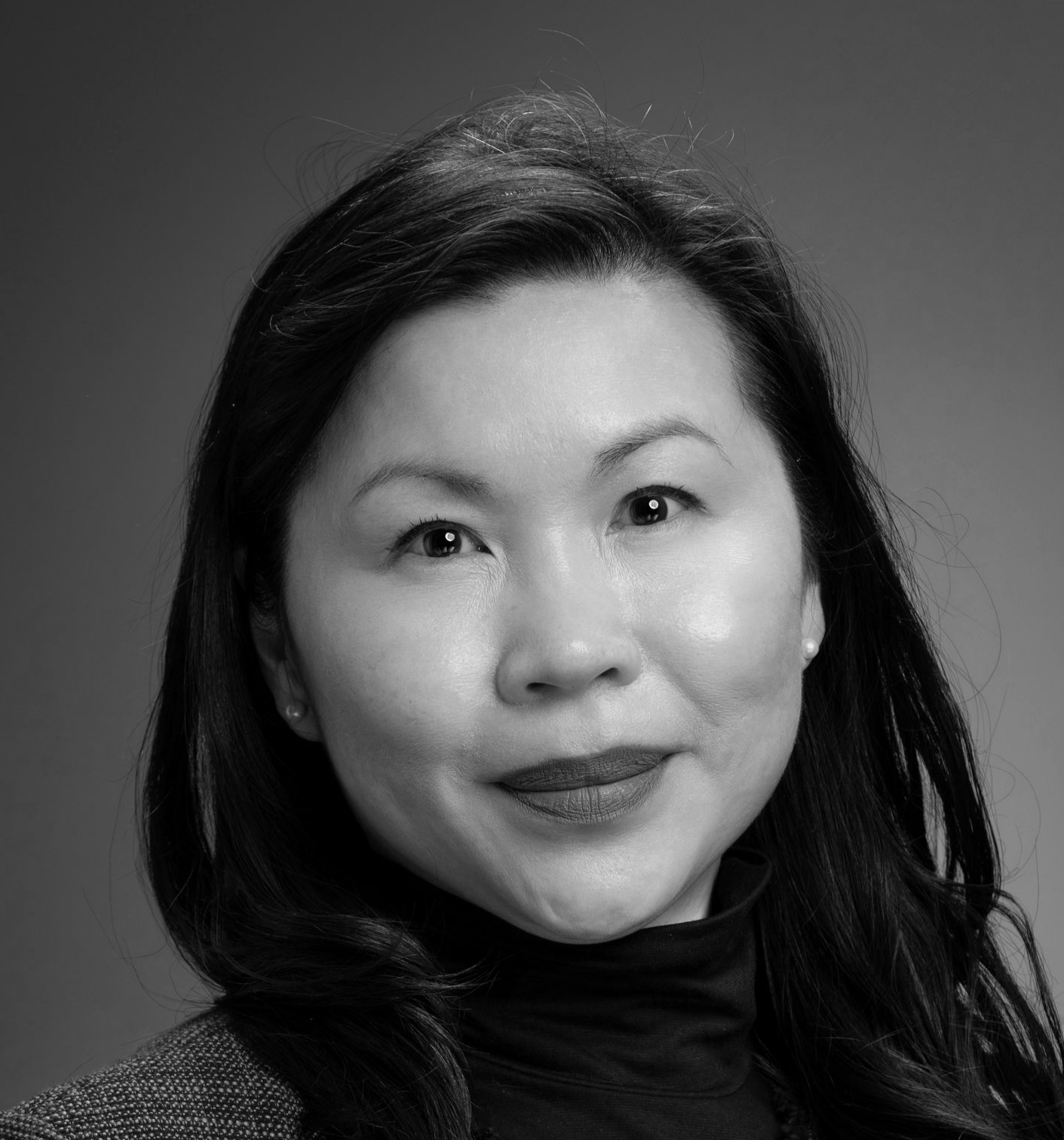 Man in a white button-down shirt smiles, looking at the camera against a white background.