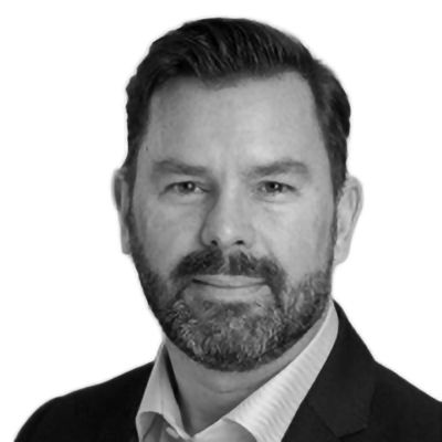 Man with beard, wearing a suit jacket and collared shirt, looking at the viewer.