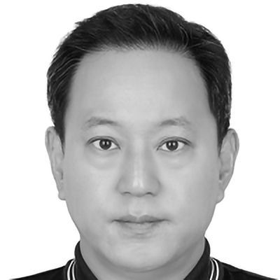 Man with short dark hair, looking directly at the viewer in a black and white photo.