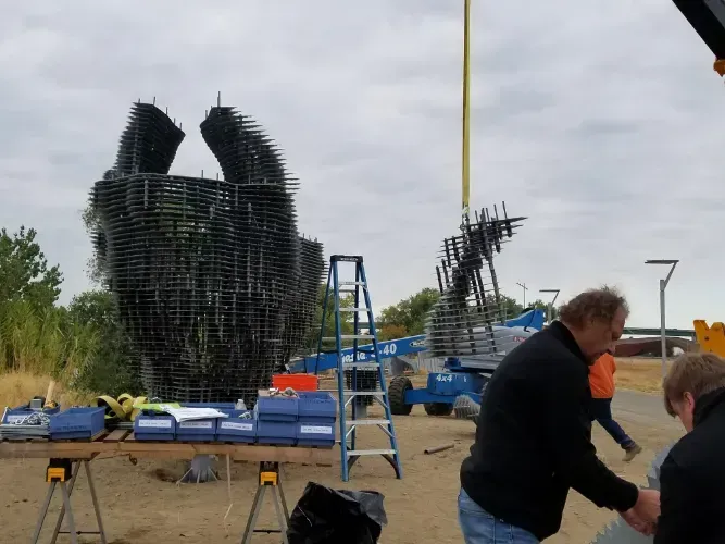 A group of men are working on a large sculpture