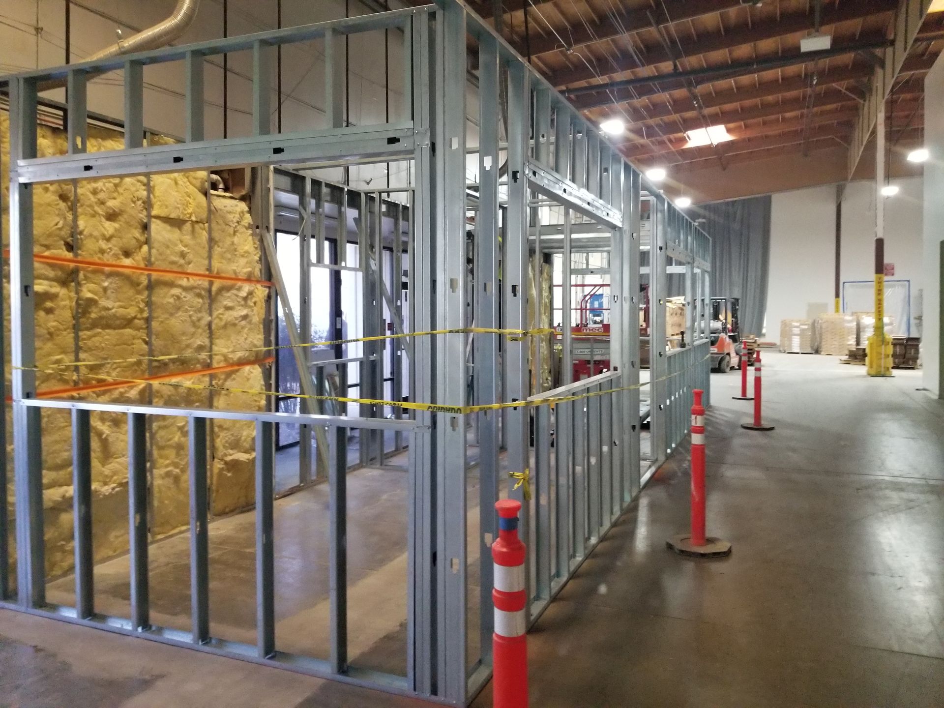 A warehouse with a lot of walls and a lot of safety cones.