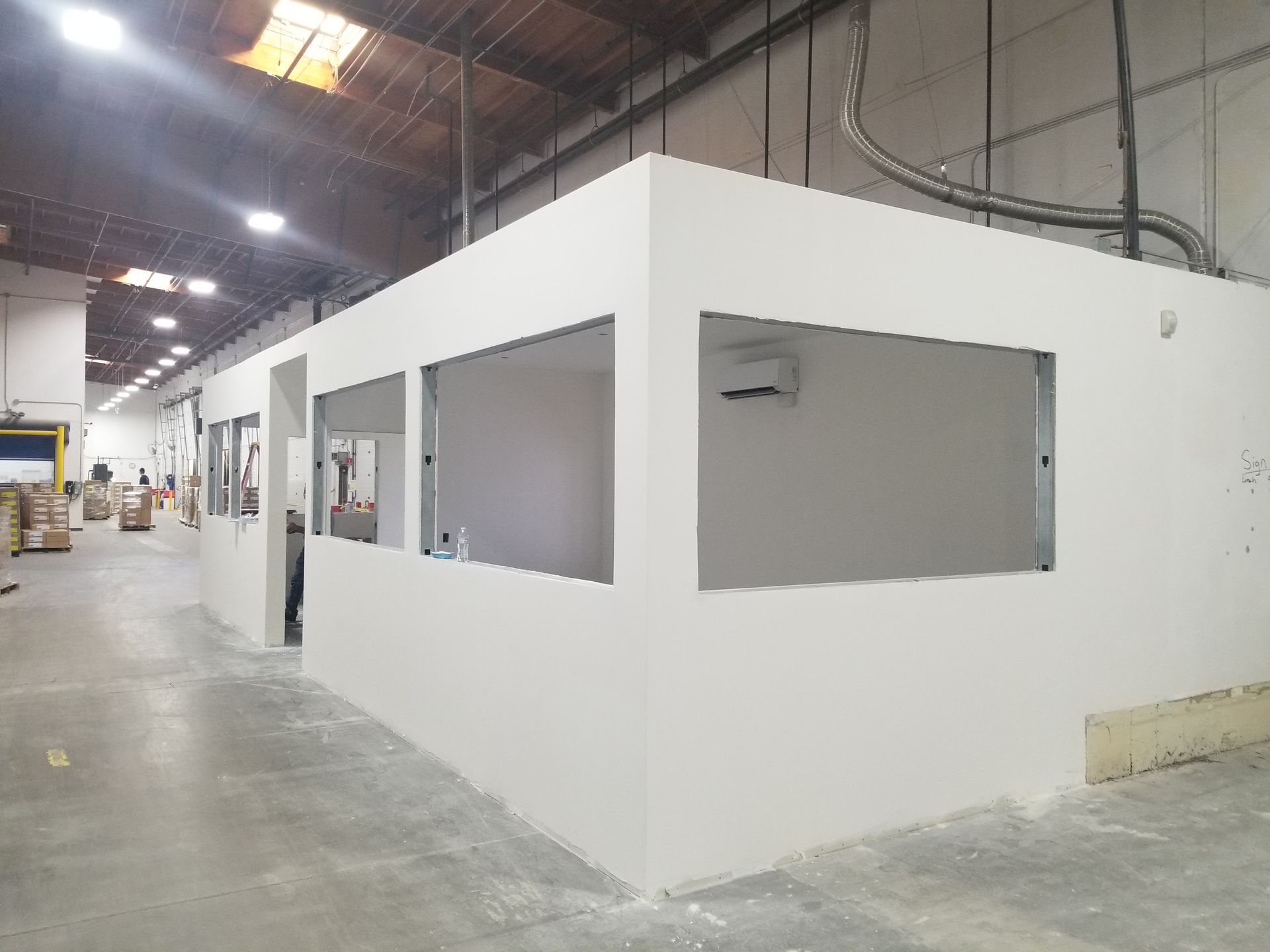 A warehouse with a lot of white walls and windows.