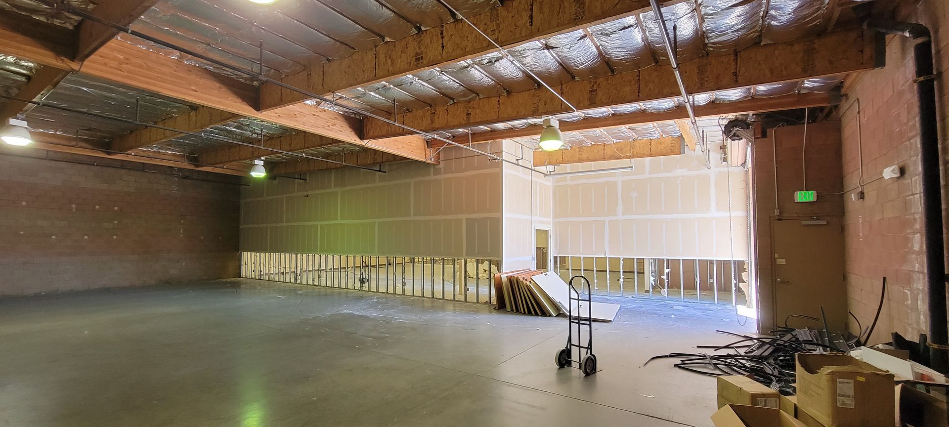 A large empty warehouse with a cart in the middle of it.