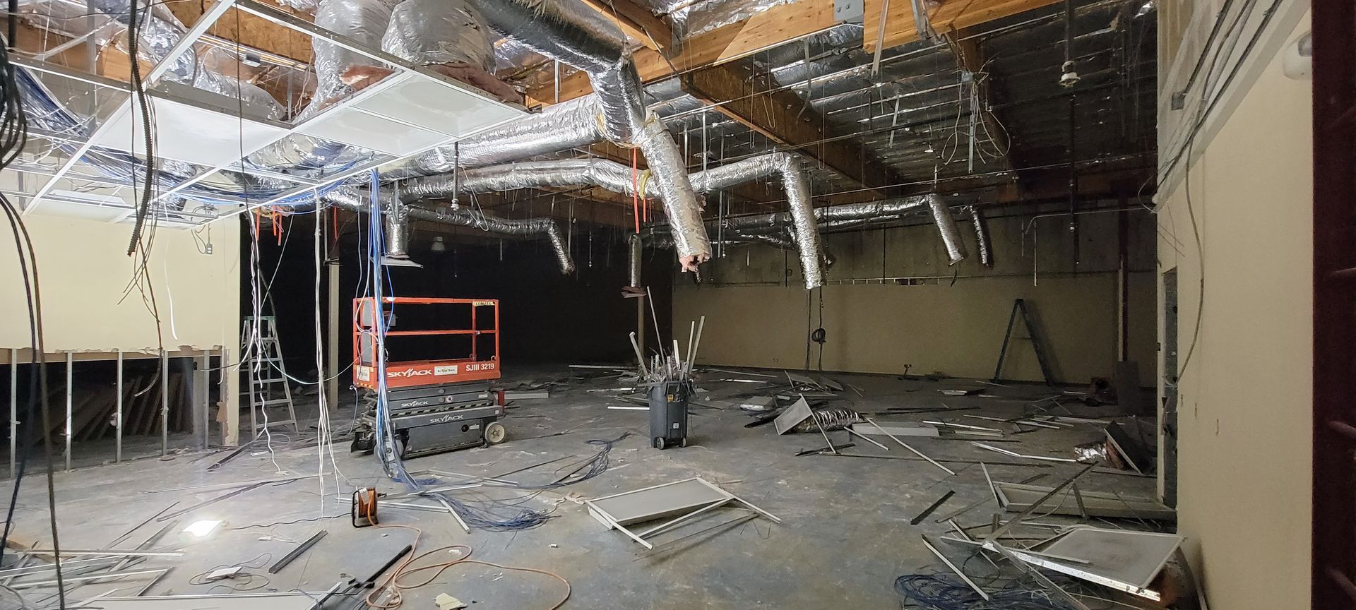 A large empty room with a ceiling that is being demolished.