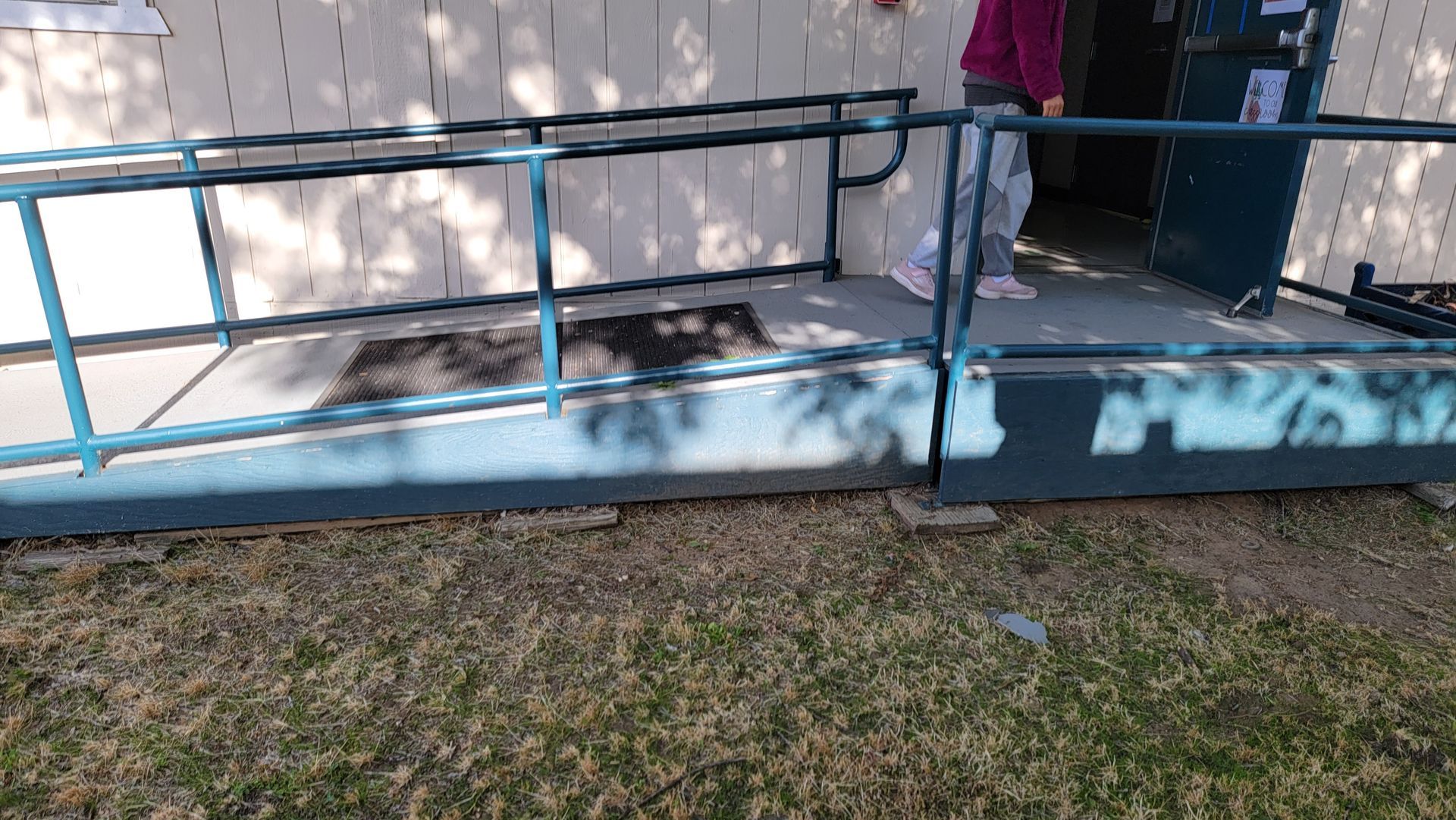 A person is standing on a ramp next to a building.