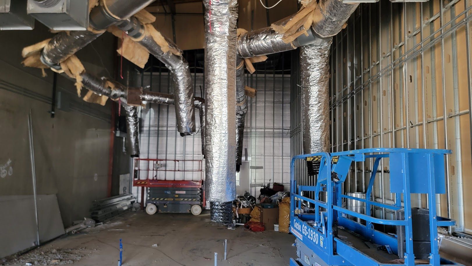 A large room with a lot of pipes hanging from the ceiling.