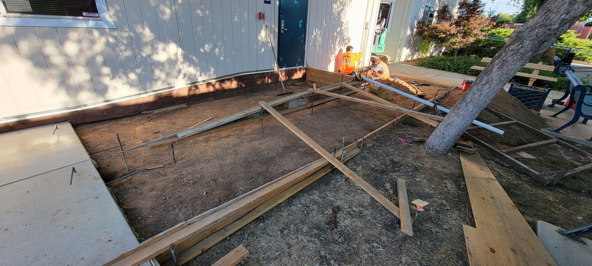 A wooden structure is being built in front of a house.