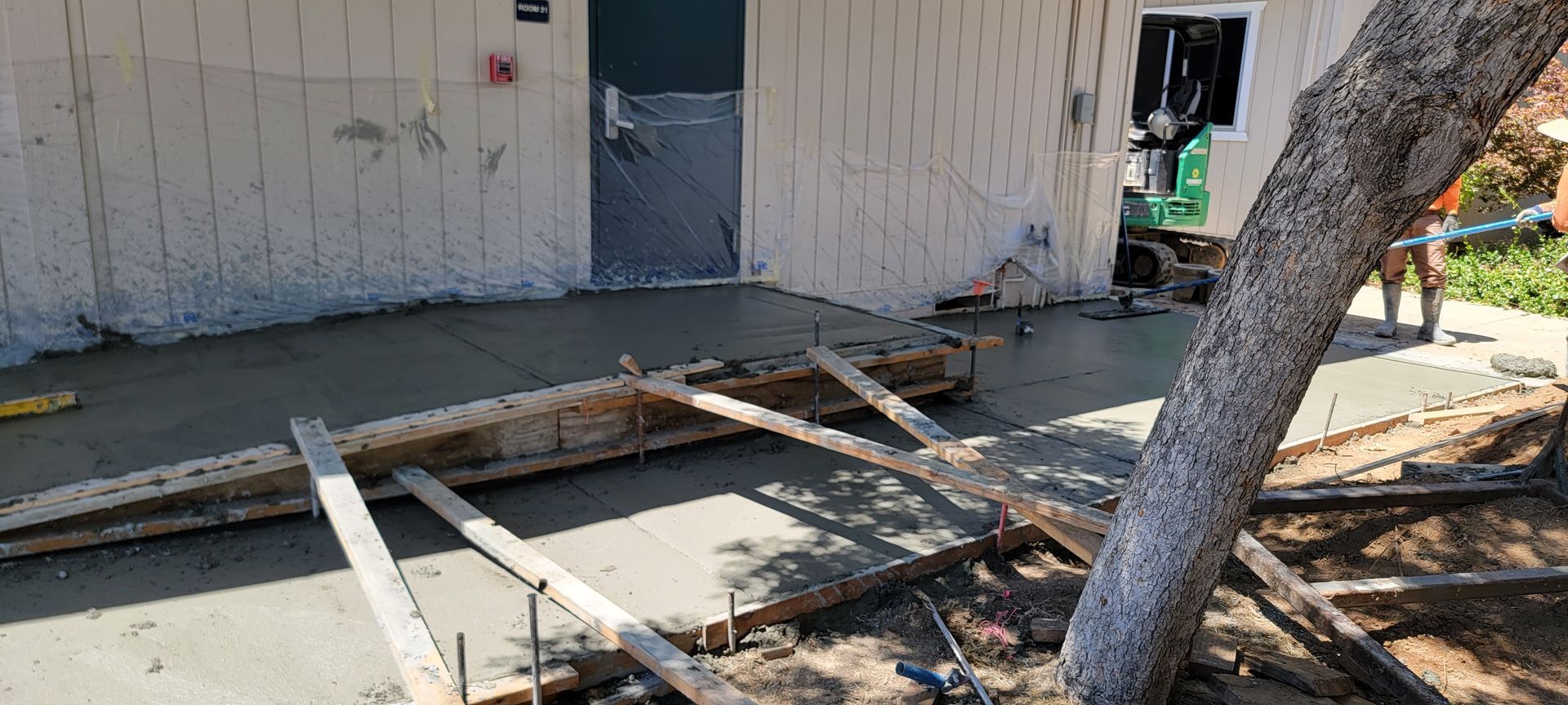 A concrete driveway is being poured in front of a house.