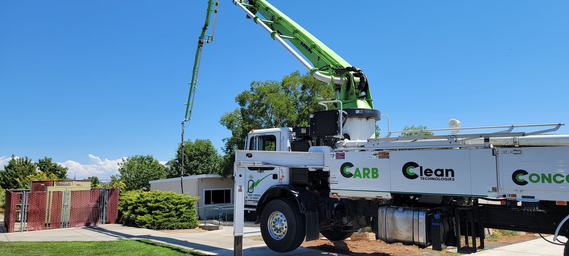 A concrete pump truck is parked on the side of the road.