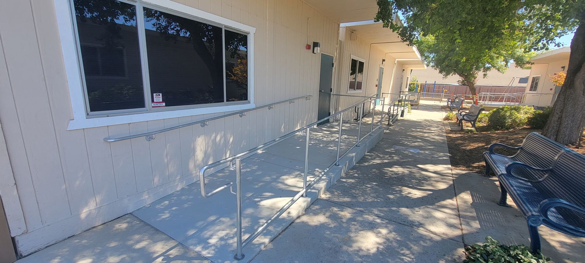 A ramp leading to a building with a bench in front of it.