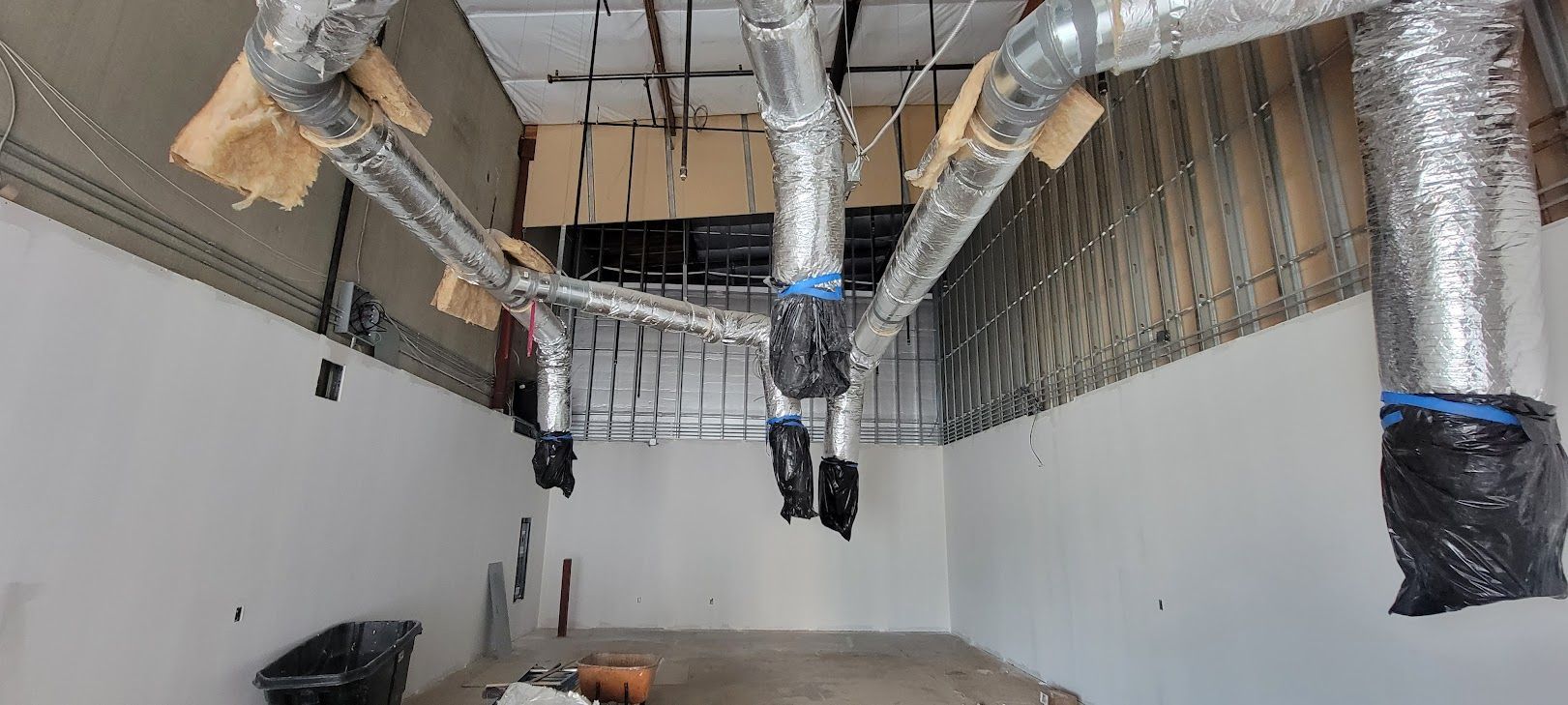 A large room with a lot of pipes hanging from the ceiling.
