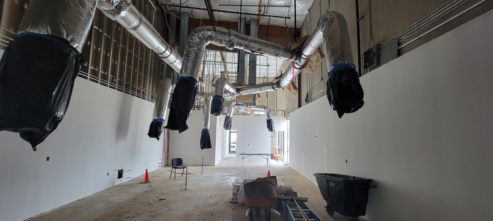 A large room with a lot of pipes hanging from the ceiling.