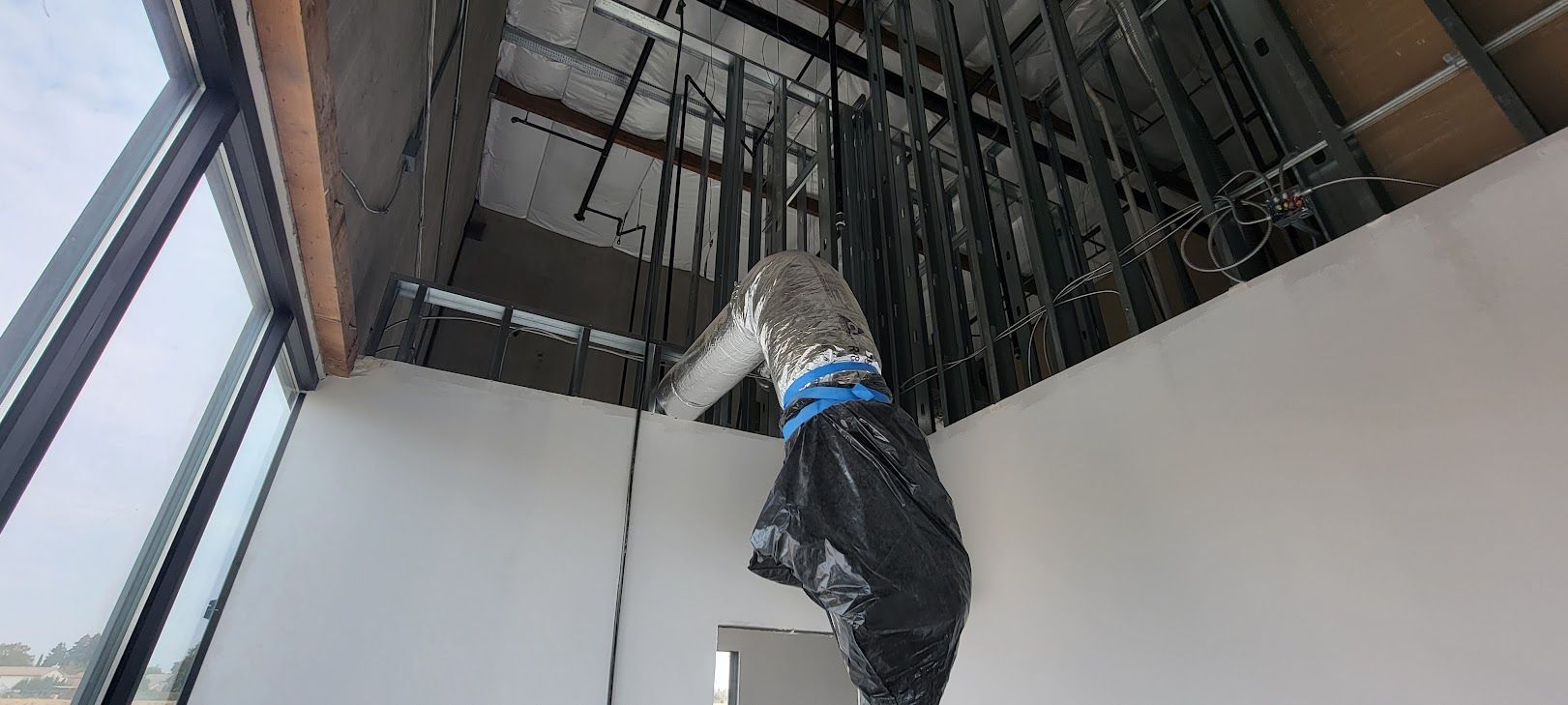 A black bag is hanging from the ceiling of a building.