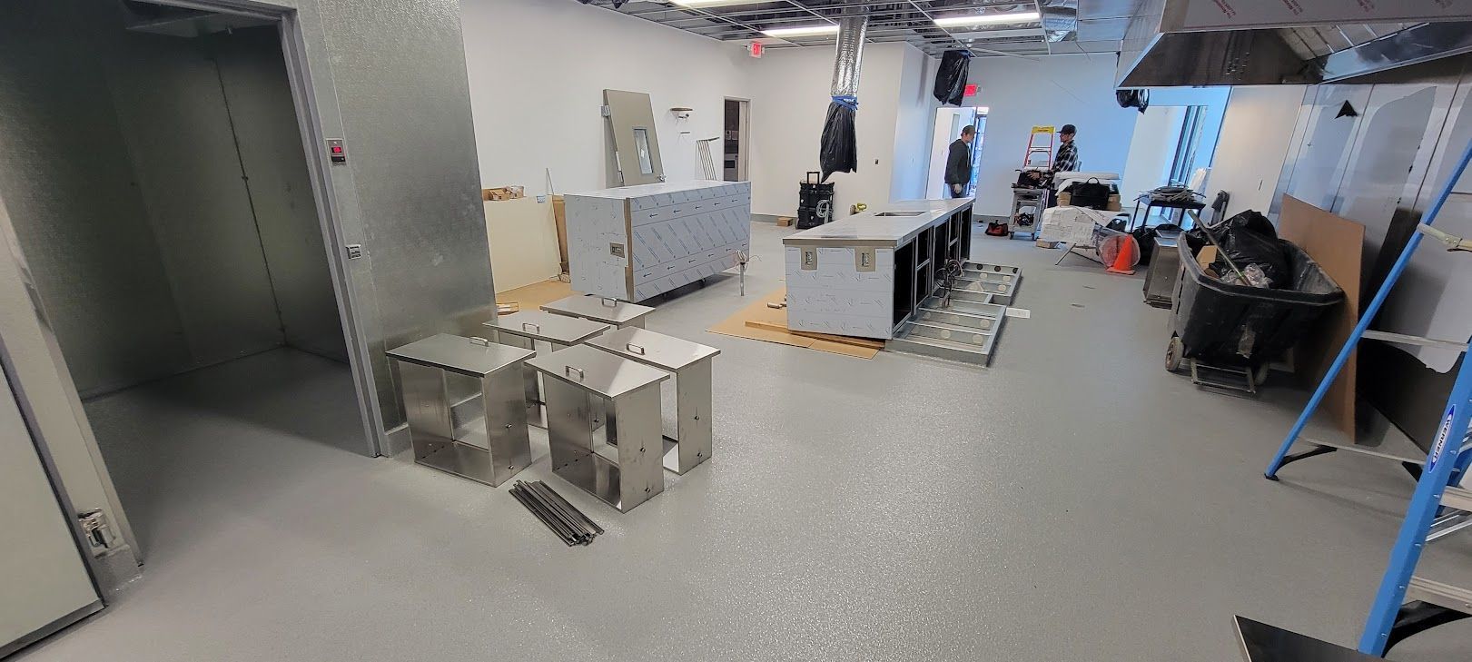 A large room with a lot of furniture and a ladder in it.