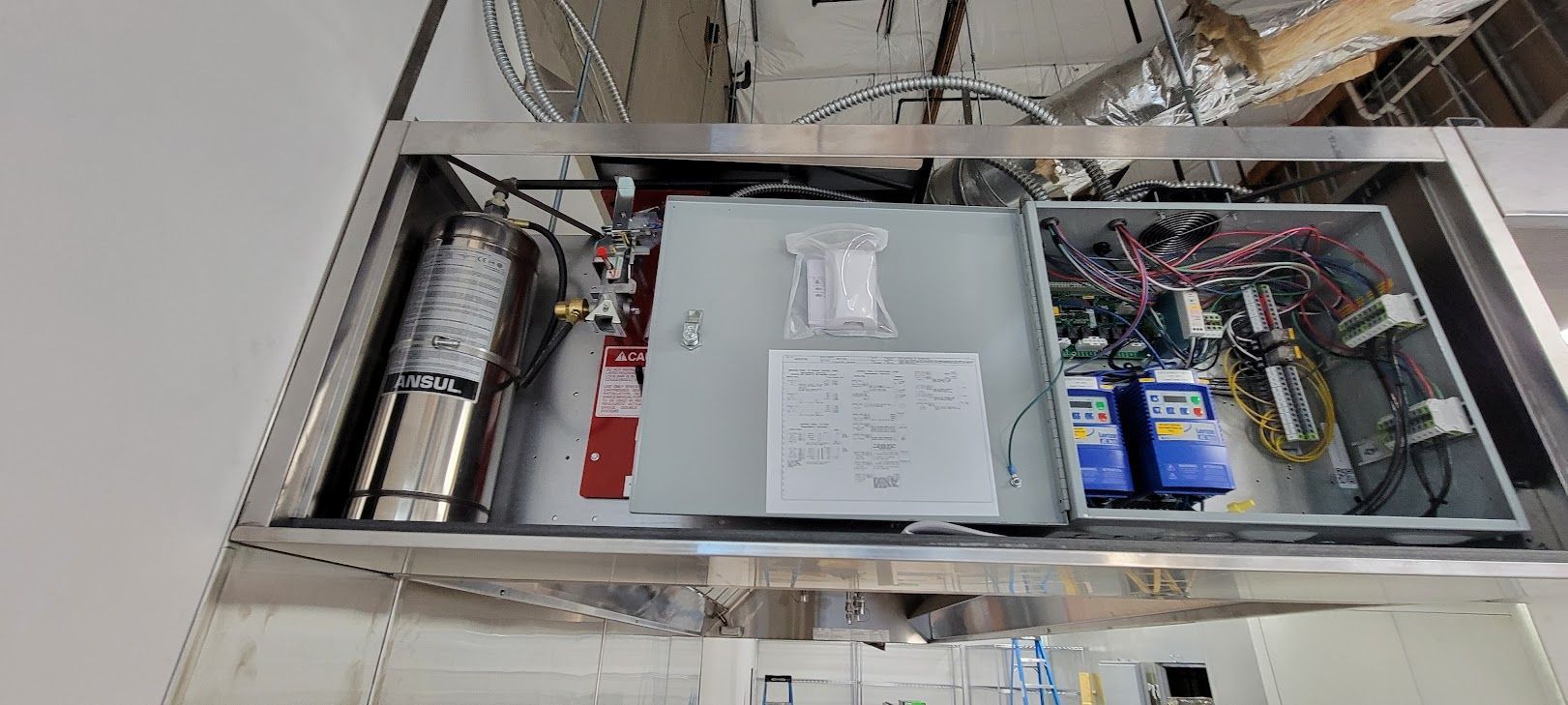 A stainless steel box filled with electrical equipment in a room.