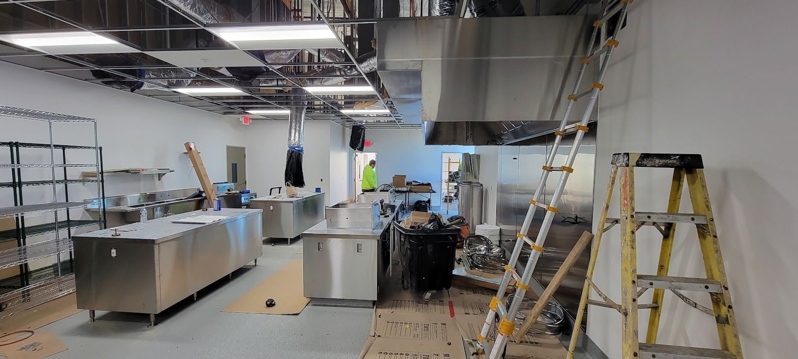 A kitchen under construction with a ladder in the middle of the room.