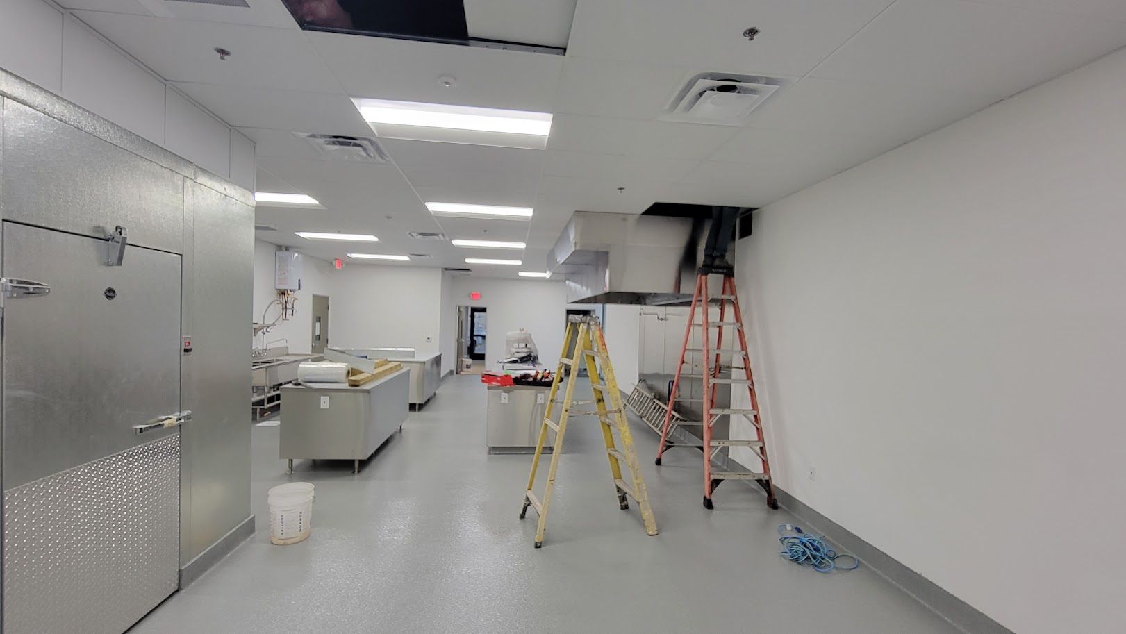 A kitchen under construction with a ladder in the middle of the room.