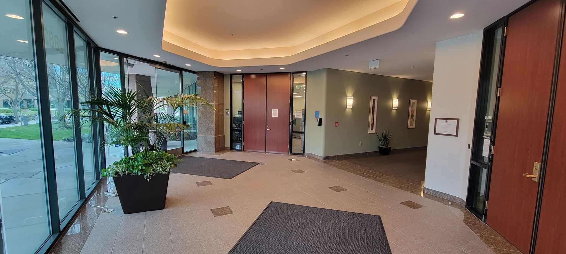 A large lobby with a lot of windows and a red door.