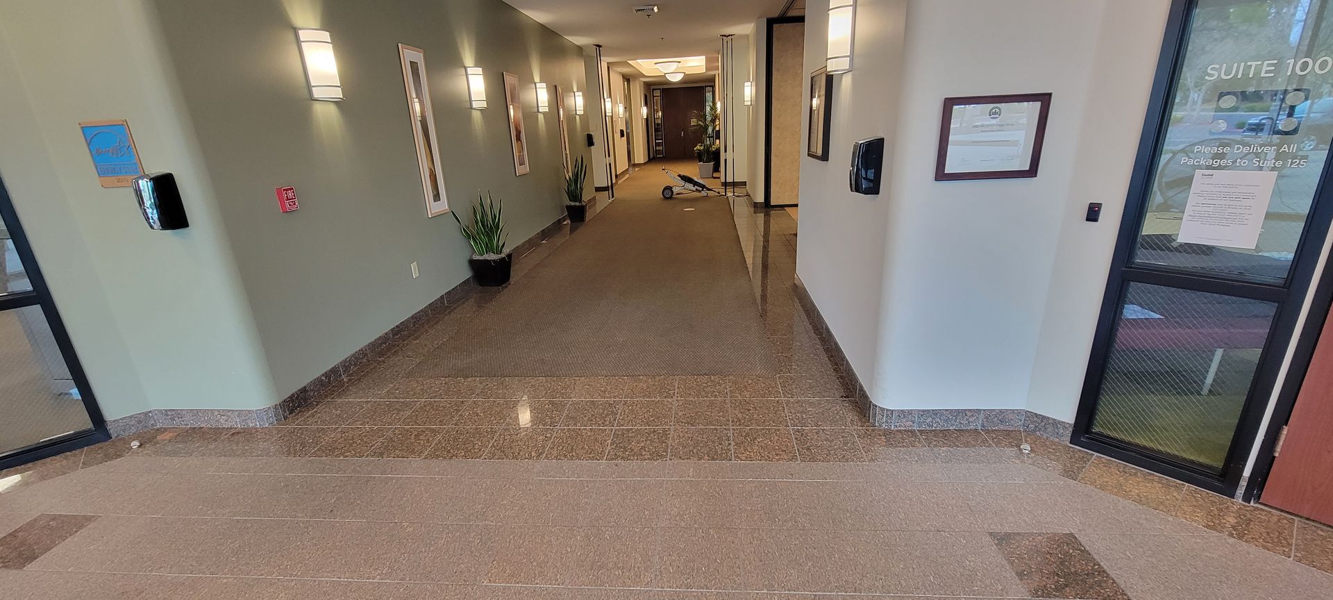 A long hallway in a building with a marble floor.