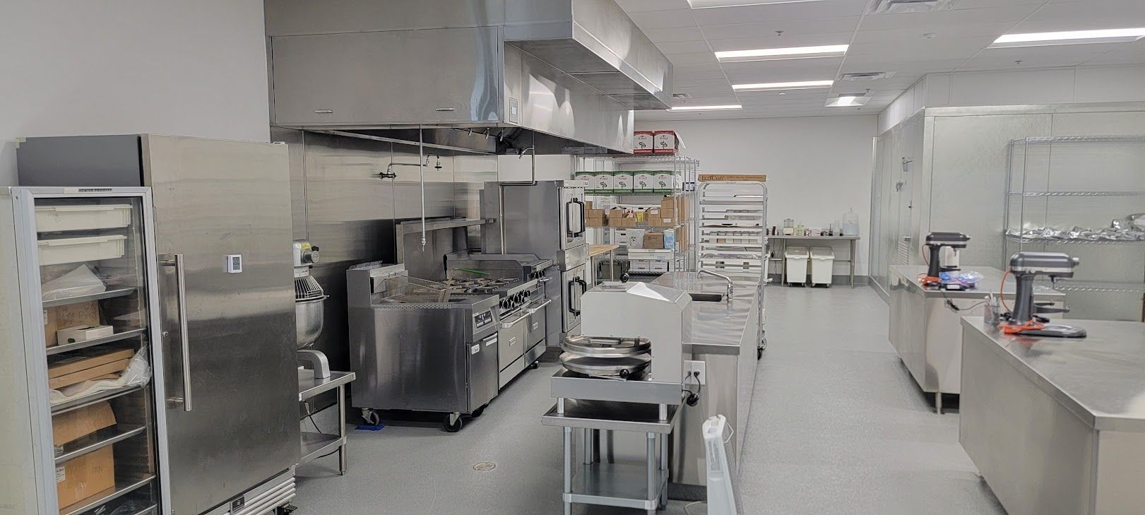 A large kitchen with a lot of stainless steel appliances.