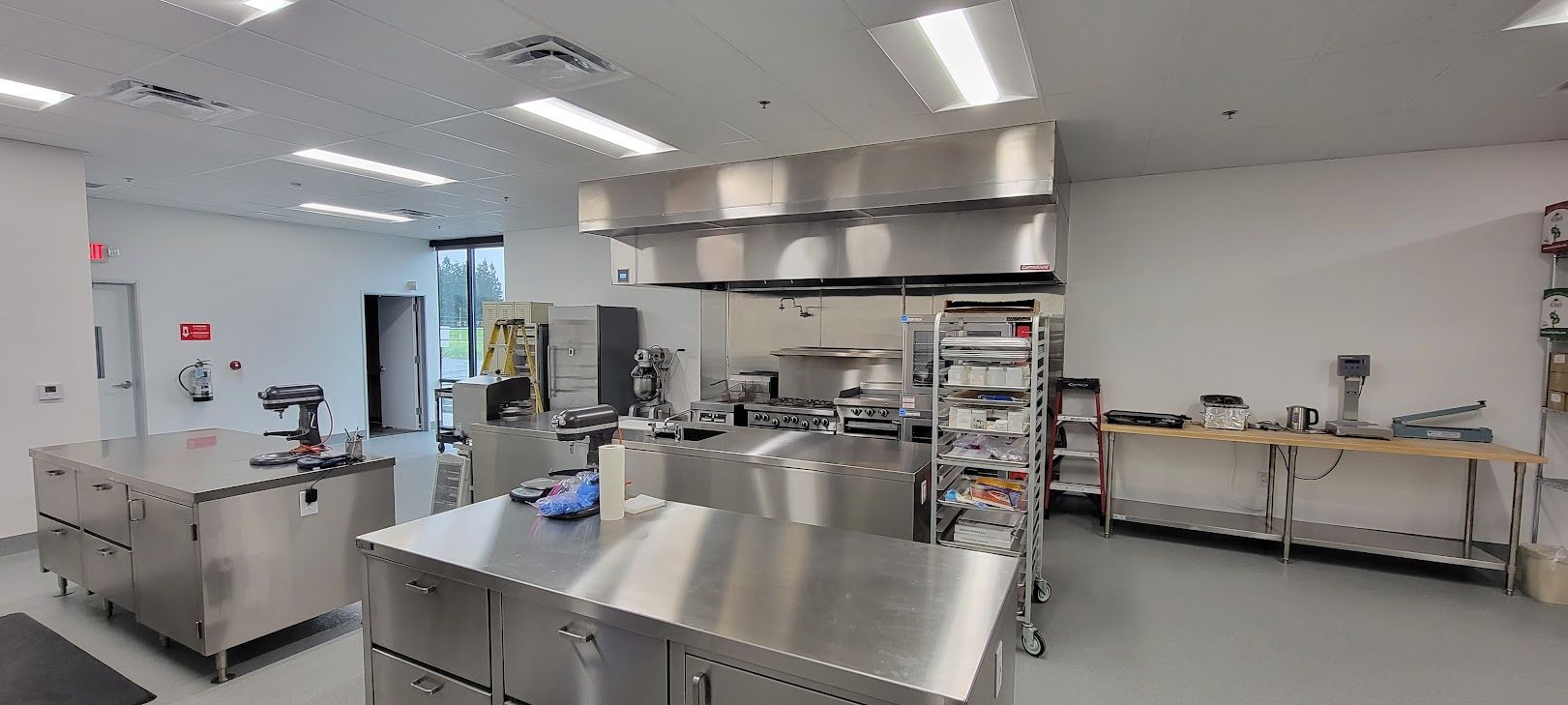 A large kitchen with a lot of stainless steel appliances.