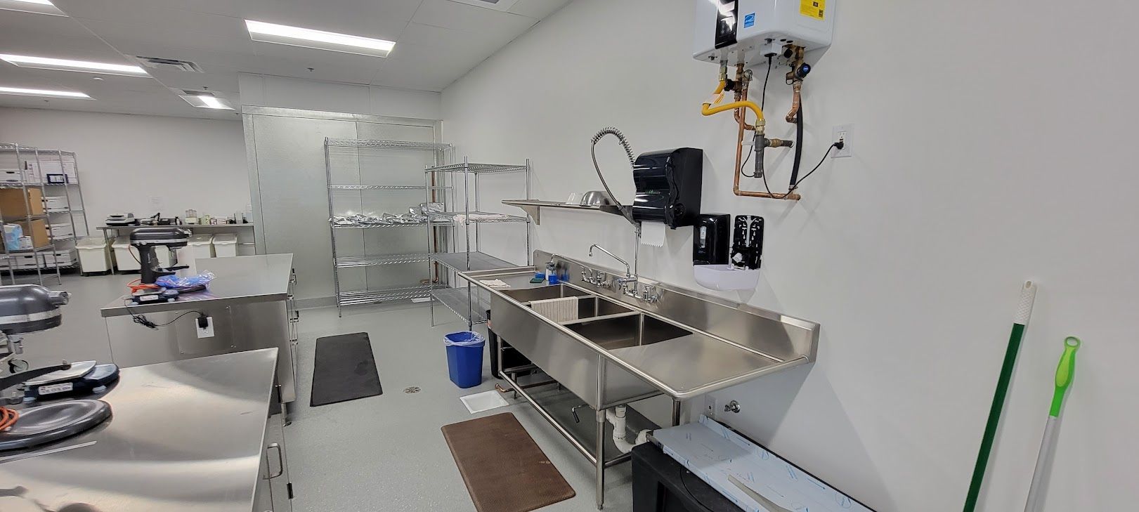 A kitchen with a lot of stainless steel appliances and sinks.
